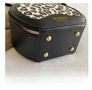 Close-up of leopard print bag bottom with gold protective studs and premium leather