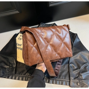 Macro detail of brown quilted faux leather texture on a stylish crossbody bag