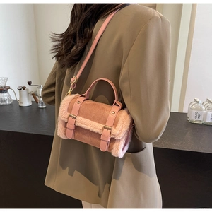 Detail of pink faux fur and leather shoulder bag worn over a beige suit blazer