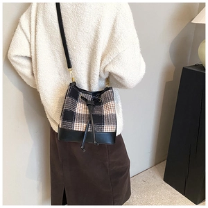 Vue arrière d'un mannequin portant un sac seau vintage en pied-de-poule et cuir