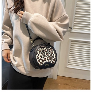 Detail of leopard print bag showing plush texture, leather trim and gold hardware