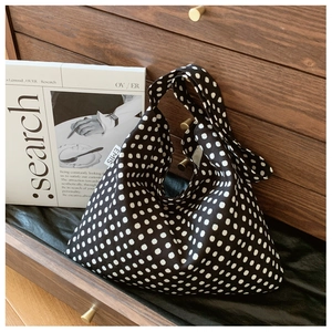 Detail of EMIS fabric tote bag with black and white polka dots in a wooden drawer