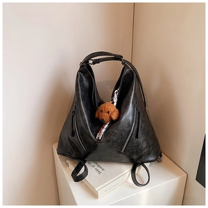 Dettaglio borsa tote nera in ecopelle con cerniere in metallo e ciondolo a forma di orso