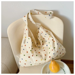 Close-up of off-white canvas tote bag with colorful polka dots and MISS label