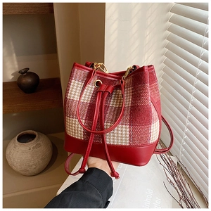 Détail du sac seau en motif pied-de-poule rouge et blanc avec cordon et crochets dorés
