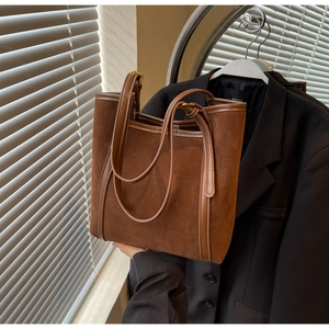 Detailed view of the dark brown suede and leather tote bag with metal buckle straps