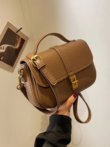 Brown lychee grain leather handbag with gold metal clasp and adjustable shoulder strap