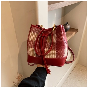 Détail du sac seau à carreaux rouge et blanc avec cordon et ferrures dorées