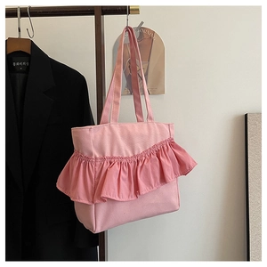 Detailed view of a pink tote bag featuring large ruffle pleats on a garment rack