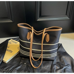 Top view of large canvas tote bag featuring brown leather straps and white striped patterns
