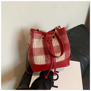 Détail du sac à cordon avec tissu pied-de-poule rouge et finitions en cuir chic