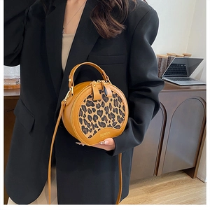 Detail of round leopard print crossbody bag with ginger leather and gold BOWEN logo