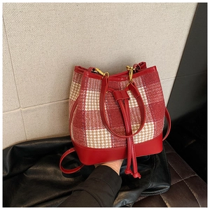 Détail du sac seau en tweed à carreaux rouge et blanc avec cordon et ferrures dorées