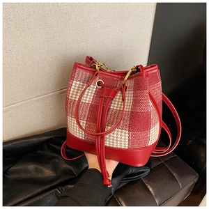 Détail du sac seau à carreaux rouge et crème avec cordon en cuir et boucles dorées