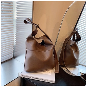 Detail view of brown leather Hobo bag featuring a front pocket and mirror reflection