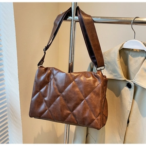 Detailed view of brown quilted crossbody bag with soft faux leather and padded texture