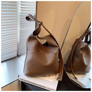 Detail of soft brown leather tote bag with large front pocket and wide shoulder strap