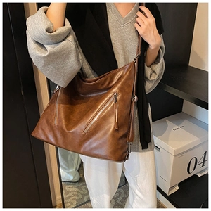 Dettaglio della borsa tote vintage in pelle PU marrone con cerniere e cinturini lunghi