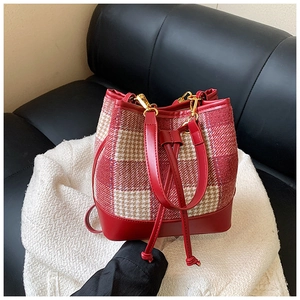 Détail du sac seau en tweed à carreaux rouge et blanc avec cordon en cuir et boucles d'or