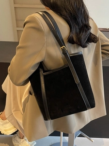 Chic black suede tote bag with smooth leather trim and adjustable gold buckle shoulder strap