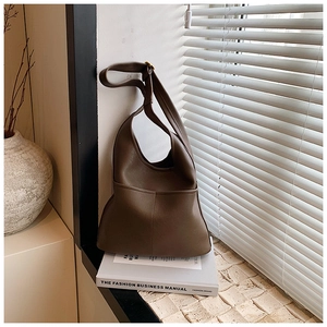 Close-up of matte coffee leather shoulder bag with fine stitching and gold buckle detail