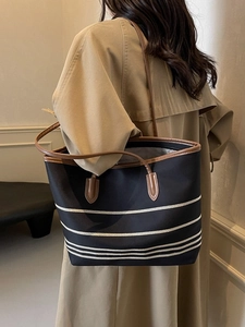 Classic black and white striped canvas tote bag with brown leather straps for commuting