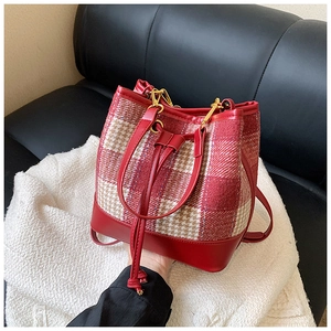 Détails d'un sac seau à motif pied-de-poule rouge et blanc sur une couverture douce