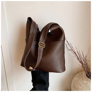 Detailed close-up of coffee brown tote bag with premium soft leather and gold metal buckle