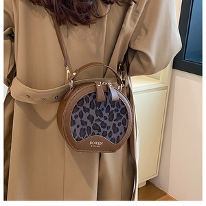 Detail of round leopard print crossbody bag with metallic zipper and BOWEN branding