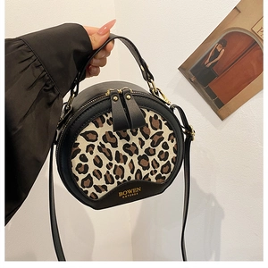 Detail of leopard print canvas bag showing the BOWEN logo and golden double zippers