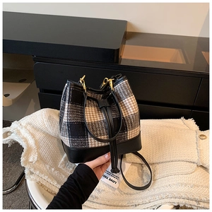 Détail du sac seau en laine pied-de-poule avec base en cuir et garnitures dorées
