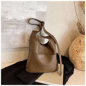 Detail of soft brown leather bucket bag showing fine texture and front seam stitching
