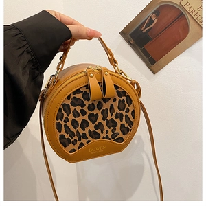 Close-up of leopard print panel on a round yellow crossbody bag with double zipper detail
