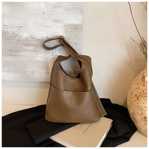 Detailed view of brown faux leather shoulder bag with adjustable strap and front pocket