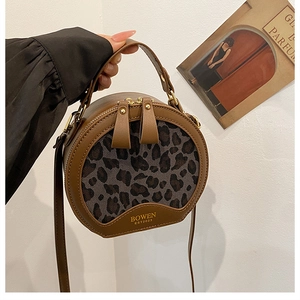 Detail of round leopard print crossbody bag in premium PU leather with gold lettering