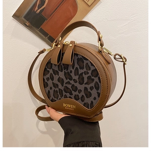 Detail of round vintage leopard print handbag featuring double zipper and leather handle
