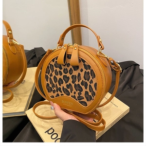 Detail of vintage round leopard print crossbody bag with dual zippers and golden hardware