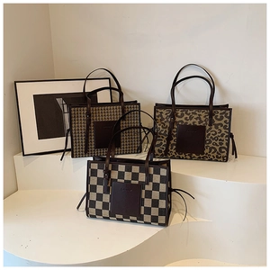 Close-up of retro tote bags in houndstooth, leopard, and checkerboard patterns with tassels