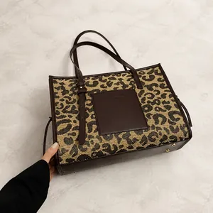 Macro detail of leopard print tote bag with dark brown leather stitching and finish