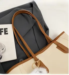 Detail of minimalist tote bag with contrast piping and plush charm on business background