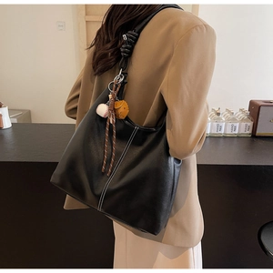 Detail of black PU leather tote with white contrast stitching and knotted rope strap detail