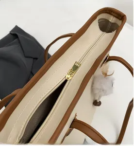 Detail of smooth metal zipper and herringbone lining on contrast trim tote bag
