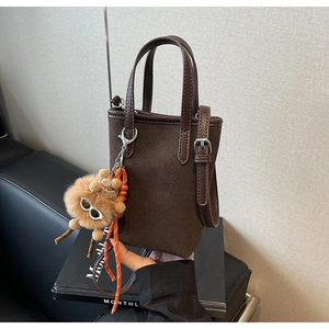 Détail du mini sac cabas en daim marron foncé mat avec breloque d'ours en peluche
