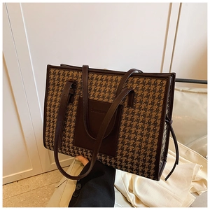 Detail of retro houndstooth tote bag featuring a leather patch pocket and premium handle