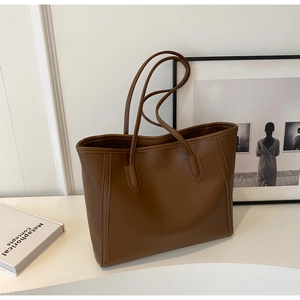 Close-up of deep brown large tote bag in premium faux leather with fine stitching details