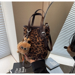 Détail du mini sac seau à imprimé léopard avec anses en cuir et charm ours en peluche