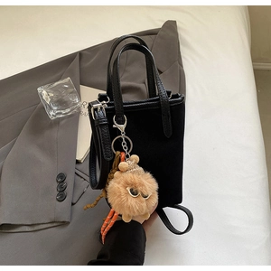 Mini sac cabas noir en simili cuir avec charmant pendentif peluche sur fond blanc