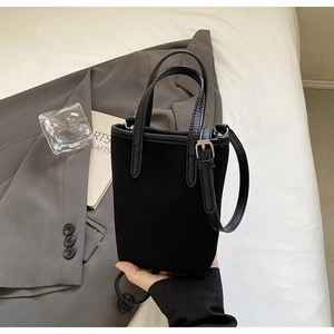 Gros plan sur le sac seau noir mat avec poignée texturée et boucle en métal argenté