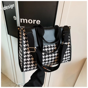 Detail of vintage houndstooth tote bag with black PU leather trim and wide shoulder straps