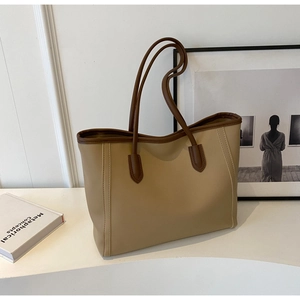 Detail view of khaki tote bag with brown leather trim and fine side stitching
